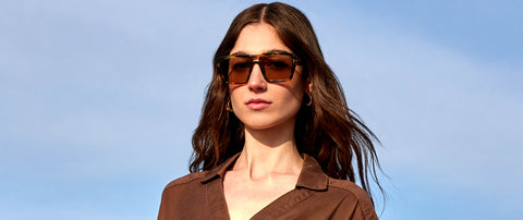Woman wearing sunglasses against a clear blue sky