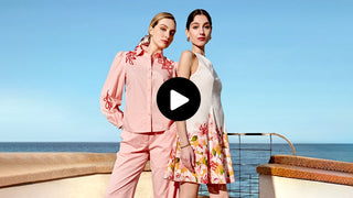 Two women on a boat with a clear blue sky and ocean background
